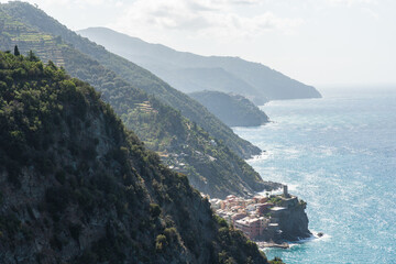panoramic view to one of Cinque Terre towns Vernazza and mountainous coastline seen from a hiking...