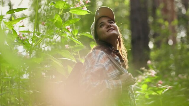 Young Caucasian woman with backpack traveling in the forest. The girl is feeling fresh, wonderful exciting and relax in nature wild. slow motion