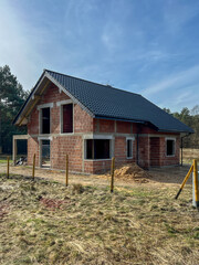 A single-family house built of ceramic blocks with a tile roof in a shell state.