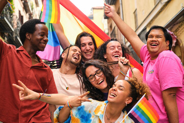 A group of people having fun and laughing with LGBTQ rainbow flags. Scene is joyful and celebratory.