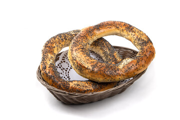 wo large poppy seed bagels in a basket isolated on white