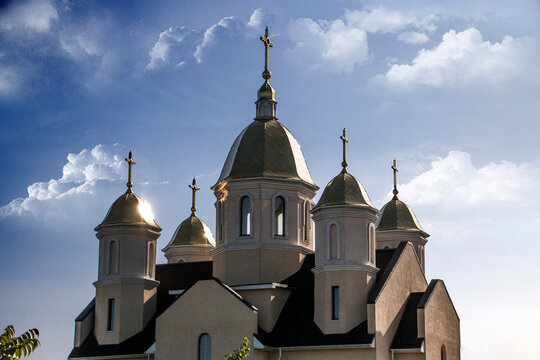 Domes with church crosses against a background of clouds and blue sky