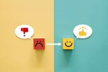 Service rating, satisfaction and positive feedback concept. Wooden block with bad face emoticon...
