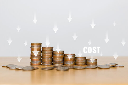 Concept of cost, lean or cost reduction. Coin stack with the word cost and down arrow for decreasing expense to maximize profits