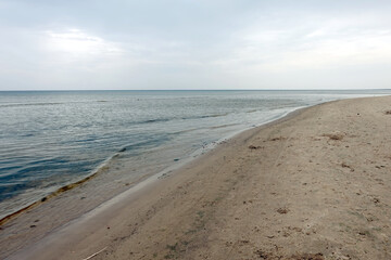 Calm waves of the Baltic Sea in the Gulf of Riga in Jurmala on empty beach on a overcast day in low season