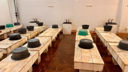 A public place for washing the body in economy class in a public bath for people. Plastic bowls for...