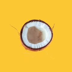 Broken coconut on a yellow background.