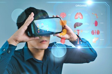 A man is holding a virtual reality device and looking at a screen with organs. Concept of exploring the human body in a new and exciting way