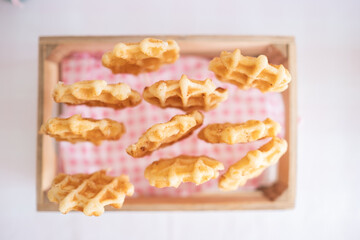 Top view of a basket filled with Easter waffles on an Easter candy table. Typical Easter sweets on...