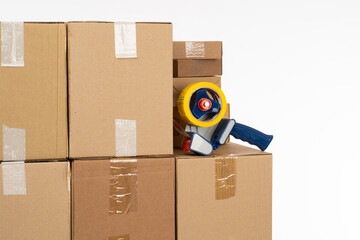 Striking Tape Dispenser on Cardboard Boxes Indicates Packing Process Against a White Backdrop