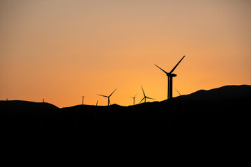 Sunset over the windmill farm in Palm Springs, California at the foot of the San Jacinto Mountains, adjacent to Highway 111, which helps provide energy for the Coachella Valley in Riverside County.