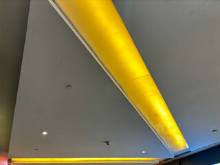 A yellow lighted ceiling with a white stripe