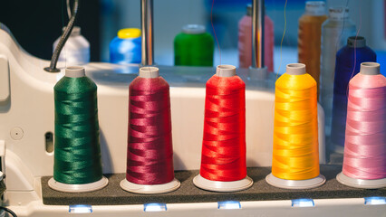 Three different colored yarns are displayed on a machine. The machine is used to create various types of textiles
