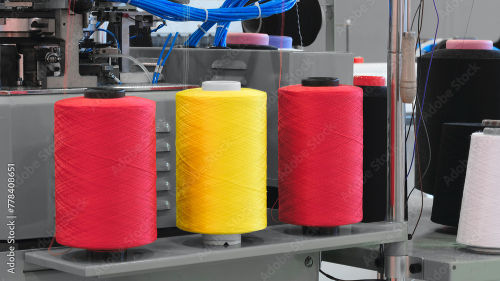 Poster three different colored yarns are displayed on a machine. the machine is used to create various type