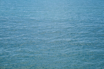 Azure blue texture of waves on the sea. Even background of slight ripples on the water.