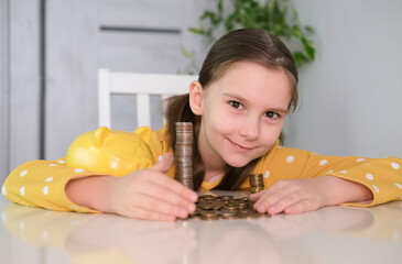 Children's palms collect coins from broken piggy bank on table. Child broke and took out his savings. Budget, finance and accounting concept.