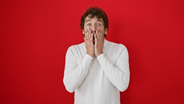 Shocked young hispanic man in sweater, fear and amazement etched on his face. alone against a red background, expressing disbelief and excitement.