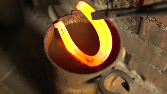 Blacksmith Forges a Hot Horseshoe Puts it in Water to Cool, Water Bubbles. A Blacksmith is a Metalsmith Who Creates Objects Primarily from Wrought Iron or Steel, but Sometimes From Other Metals.