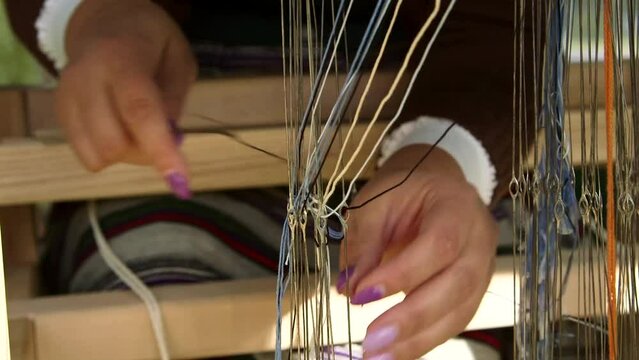 Woman Preparing to Weave on a Loom. Arranging the Threads through Eyelets. Weaving is a Method of Textile Production in Which Two Sets of Yarns are Interlaced to Form a Fabric or Cloth.