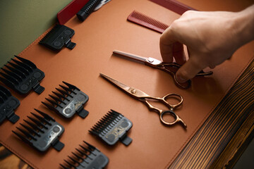 Hairdressing shears in hands of hairstylist in barbershop