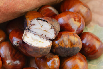 Raw chestnuts on a bed of leaves