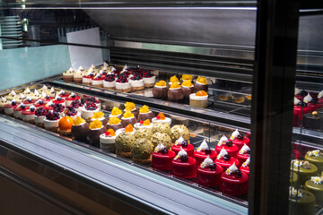 Lots of colorful and tasteful cakes in a patisserie shop