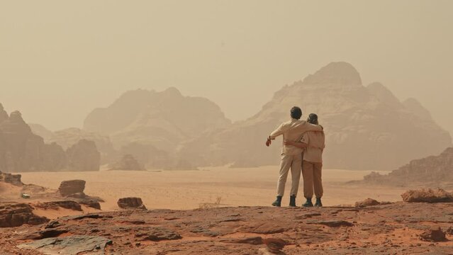 Hikers in Jordan desert looking at landscape