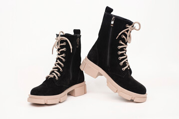 Suede dark boots with a light high sole on a light background. Comfortable boots for women and girls, autumn or spring