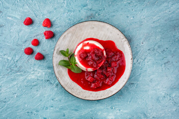 Traditional quark mousse with rhubarb and raspberry compote served as top view on a Nordic Design...