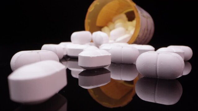 White Pills Spilled from Prescription Bottle