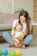 Vertical shot of a young mother playing together with her sweet daughter at home.