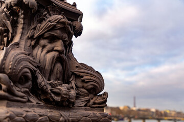 Cast iron decorative ornament with human face, lantern on a bridge in Paris, France