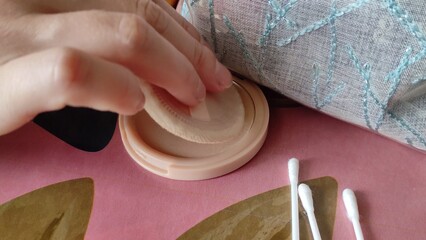 Woman using face powder makeup. Woman hand hold face powder. Close-up video