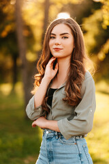 Vertical outdoors shot of a young beautiful woman standing in park on a sunny day.