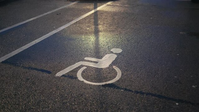 Parking for all: Handicapped or disabled sign displayed on the asphalt, designating an inclusive parking area
