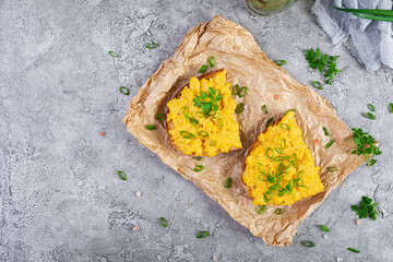 Scrambled eggs with herbs and toasts. Delicious breakfast with eggs and herbs. Top view