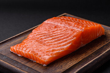 Fresh raw salmon steak with spices and herbs prepared for grilled baking