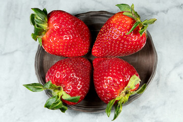 Close-up of a group of four strawberries on a plate