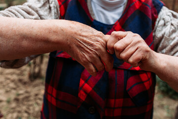 Elderly woman showing cramped finger on her hand - obrazy, fototapety, plakaty