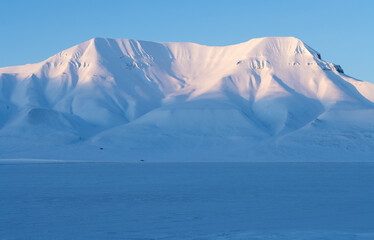 Mountains and frozen fjord in Svalbard at sunset