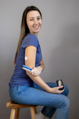 Girl sitting with sensor glucose patch on her arm