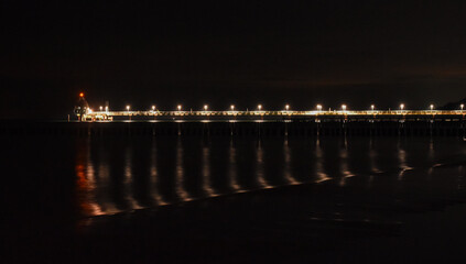 illuminated pier at night in the baltic sea in Germany - obrazy, fototapety, plakaty