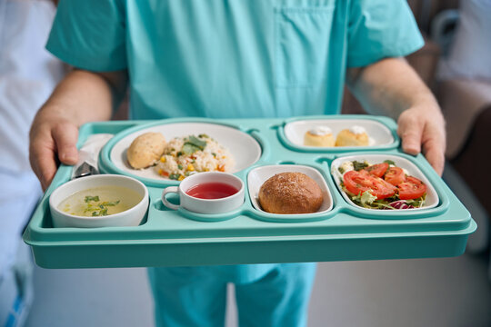 Nurse is serving dietary food in inpatient facility ward