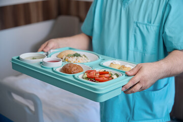 Nursing assistant serving fresh organic food in healthcare facility ward - 778467270