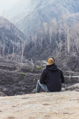 lonely man sitting on the slopes of the turrialba volcano