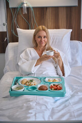 Tranquil patient having herbal beverage during lunchtime in ward - 778472297