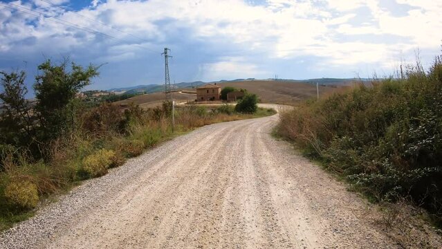Via Francigena - gravel road in the countryside with a view to Torrenieri, Montalcino, Province of Siena, Tuscany, Italy