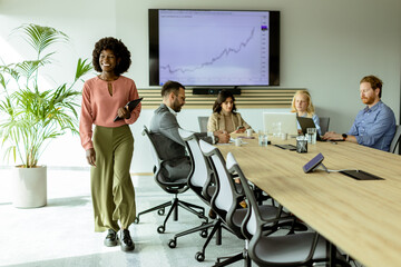 Fototapeta premium Radiant African American businesswoman with tablet ready to present in modern conference room