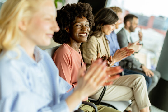 Energetic applause by a diverse group at a casual indoor event