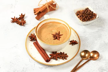 Foto op Plexiglas anti-reflex Cup of coffee with milk, ginger, anise and cinnamon on an old concrete table. Traditional Indian drink with spices, cafe concept, advertising for restaurant and menu © Светлана Балынь